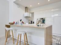 a kitchen with white cabinets and white stools at Holiday Home Le Chant Des 4 Sirènes by Interhome in La Teste-de-Buch