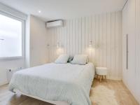 a white bedroom with a large bed and a window at Holiday Home Le Chant Des 4 Sirènes by Interhome in La Teste-de-Buch