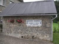 a stone building with a sign on it at Maison Chabrat in Liginiac