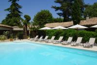 - une piscine avec des chaises longues et des parasols dans l&#39;établissement Hôtel la Magnaneraie, à Villeneuve-lès-Avignon