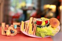a plate of food with a sandwich and a bowl of fruit at Locking B&amp;B台東民宿 in Taitung City