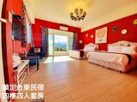 a bedroom with red walls with two beds and a desk at Locking B&amp;B台東民宿 in Taitung City