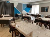 a dining room with tables and chairs with white tablecloths at Hotel Bussana in Porto Tolle
