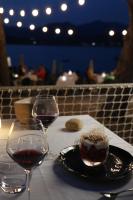 a table with two glasses of wine and a bowl of food at Hôtel Castel d'Orcino in Calcatoggio