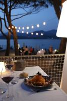a plate of food on a table with a glass of wine at Hôtel Castel d'Orcino in Calcatoggio