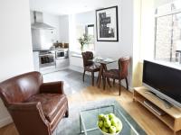 a living room with a television and a table with a bowl of apples at 196 Bishopsgate in London