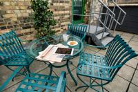 a glass table with three chairs and a plate of food on it at 196 Bishopsgate in London