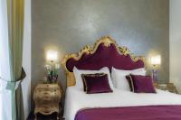 a bedroom with a large bed with purple and white pillows at Hotel Concordia in Venice