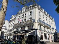 a large white building with people sitting outside of it at Hôtel France et Chateaubriand in Saint Malo