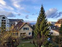 a house in a city with a tree at Appartement du parc des thermes in Thonon-les-Bains