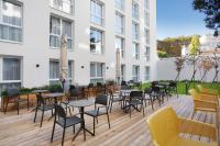 un patio avec des tables et des chaises en face d&#39;un bâtiment dans l&#39;établissement Odalys City Toulouse Centre Compans Caffarelli, à Toulouse