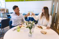 メストレにあるノボテル ベネチア メストレのワインを飲むテーブルに座る男女