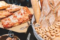 メストレにあるノボテル ベネチア メストレのピザとプレッツェルと食べ物の皿が置かれたテーブル