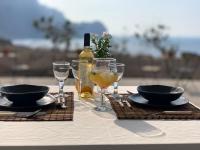 una mesa con copas y una botella de vino en Palmeira Da Cruz EcoLodge, en Chã da Igreja