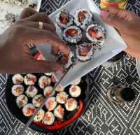 una persona cortando una caja de sushi con un cuchillo en Palmeira Da Cruz EcoLodge, en Chã da Igreja