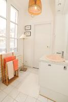 a bathroom with a sink and a table and a chair at Le Jardin Cathedrale in Chartres