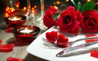 una mesa con un plato con rosas rojas y velas en Central Bruges B&amp;B, en Brujas