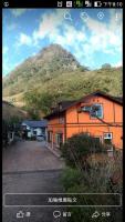 an orange building with a mountain in the background at Natural Residence B&amp;B in Tai&#39;an