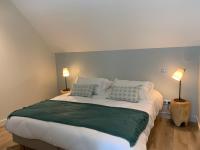 a bedroom with a large bed with two lamps at Les Cotonnades Lorient in Lorient