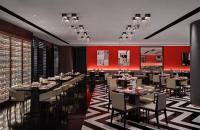 a restaurant with tables and chairs and red walls at Niccolo Chengdu in Chengdu