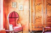 a room with a red chair and a wooden cabinet at Hôtel Du Théâtre Centre Historique Parking Gratuit in Metz