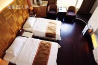 a hotel room with two beds and chairs at River Forest Leisure Farm in Dongshan