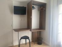 a room with a cabinet and a stool and a television at Hotel Restaurant Noblia in Bidarray