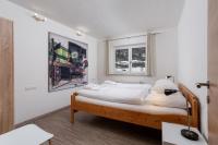 a bedroom with a bed with white sheets and pillows at Alpine View Apartments in Niedernsill