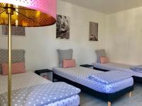 a room with three beds and a pink lamp at House with garden Disneyland Paris in Magny-le-Hongre
