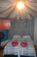 a bed with two red hats on top of it at Pousada Grão in Belém