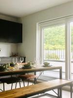a dining room with a table and a large window at Chez petit Gust Welkom in La Roche en ardenne in La Roche-en-Ardenne