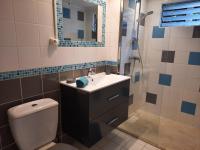 a bathroom with a toilet and a sink and a shower at Villa Kannel in Petit-Bourg