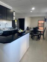 Una cocina con fregadero y una mesa con sillas. en Apartamento Ucha, en Ríohacha