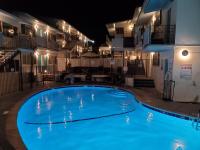 ein großer blauer Pool in der Nacht mit Gebäuden in der Unterkunft Inn at East Beach in Santa Barbara