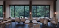 a restaurant with tables and chairs and large windows at Guilin Yangshuo Jora Hotel in Yangshuo