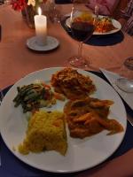 a plate of food on a table with a glass of wine at Tanzanice Farm Lodge in Karatu