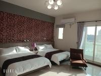 two beds in a bedroom with a brick wall at Happy Life B&amp;B in Donggang