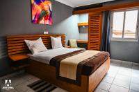 Un dormitorio con una cama grande y una ventana. en Hotel Astoria, en Douala
