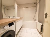 a bathroom with a washing machine and a sink at Standing appartement avec vue sur la Mayenne in Laval
