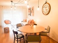 a living room with a table and a clock on the wall at Standing appartement avec vue sur la Mayenne in Laval