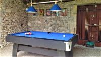a pool table in front of a stone wall with lights at Manoir du Bois Mignon in Le Fleix