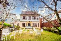 a group of chairs and tables in front of a house at Moonlake B&amp;B in Yuchi