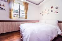 a bedroom with a white bed and a window at Moonlake B&amp;B in Yuchi