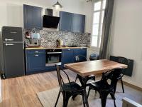 Una cocina con gabinetes azules y una mesa de madera con sillas. en République - Dauder de Selva, en Perpiñán