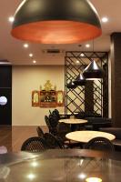 a restaurant with tables and chairs and aendant light at Hotel Eastern Bojonegoro in Bojonegoro