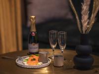 Una mesa con un plato de comida y dos copas de vino. en Dandy Hotel & Kitchen, en París