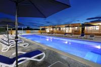 a pool with chairs and umbrellas at night at Poolside Mobile Home in Turanj