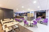 a restaurant with purple chairs and tables at Park Inn by Radisson Göttingen in Göttingen