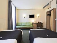 a hotel room with two beds and a green couch at Campanile Dijon Centre - Gare in Dijon