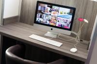 a desk with a computer monitor and a keyboard and mouse at Best Western Hotel Le Bordeaux Sud in Gradignan